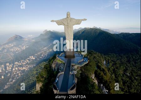 Christ the Redeemer statue at sunrise with Botafogo Beach and the bay down below. At a height of 130 feet, the statue is the world's tallest. It we... Stock Photo