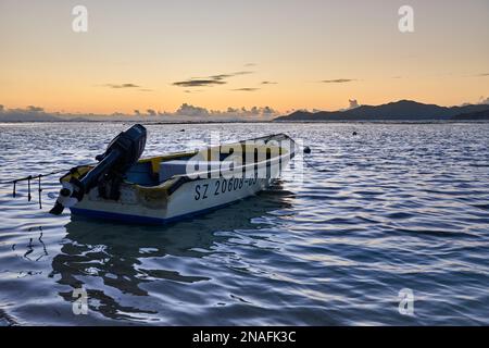 small boat during sunset on sea of La Digue, Seychelles Stock Photo
