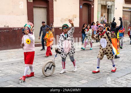 A parade of clowns on the Macedonio Alcala pedestrrian street in the historic center of Oaxaca, Mexico at Christmas time.. Stock Photo