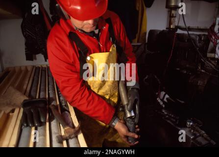 Looking for diamonds, a driller gets a core sample from a drill pipe; Yellowknife, Northwest Territories, Canada Stock Photo