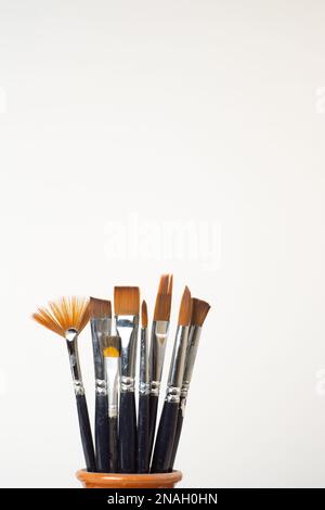 earthenware jar with brushes isolated on a white background Stock Photo