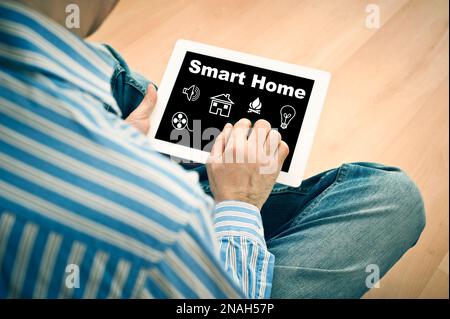 man holding a computer tablet with smart home controls on screen Stock Photo