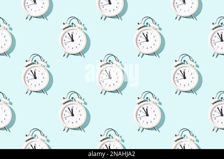 Seamless pattern of white alarm clocks on bright light blue background. Conceptual sunlight background. Stock Photo