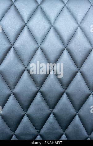 Quilted black leatherette surface close-up photography. Stock Photo