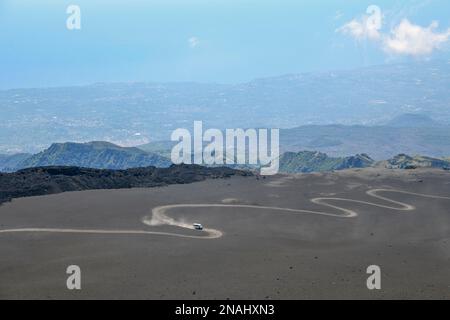 Off-road vehicle that transports tourists to the top of the volcano, on a sandy track in the summit region of Etna, Province of Catania, Sicily, Italy Stock Photo