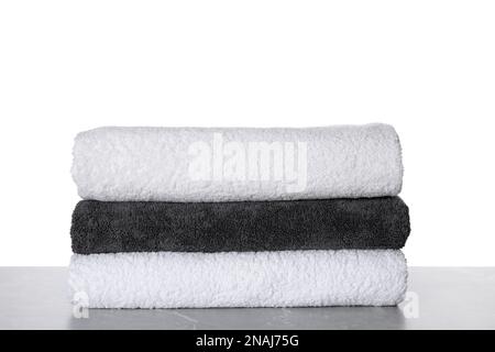 Stacked soft towels on table against white background Stock Photo