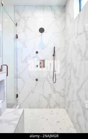 Large Walk-In Shower with Marble Tile, Seamless Glass Door, Antique Brass Fixtures Stock Photo