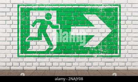 Exit sign on white brick wall Stock Photo