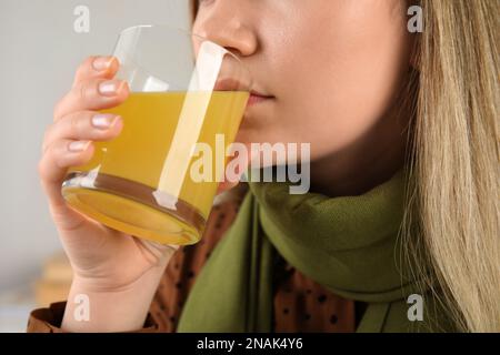 Woman drinking dissolved cold relief powder indoors, closeup Stock Photo