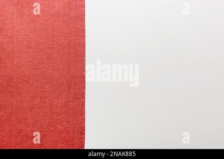 top view with red empty kitchen napkin isolated on table background. Folded cloth for mockup with copy space, Flat lay. Minimal style. Stock Photo