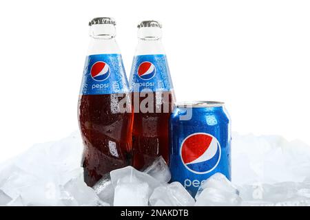 MYKOLAIV, UKRAINE - FEBRUARY 11, 2021: Glass bottles and can of Pepsi on ice cubes against white background Stock Photo