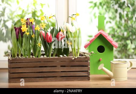 Different beautiful spring flowers with birdhouse on window sill Stock ...