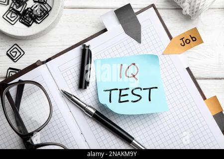 Sticky note with text IQ Test and stationery on table, flat lay Stock Photo