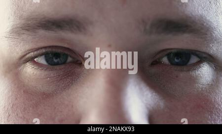 Person closing eyes in meditation and opening looking at camera. Macro close up of calm man eye in contemplation Stock Photo