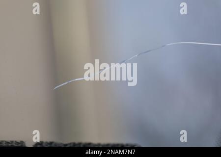 Cracked windshield in the car, close-up of scratches on the glass. Stock Photo