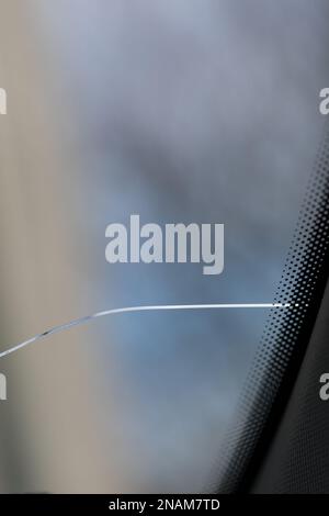 Cracked windshield in the car, close-up of scratches on the glass. Stock Photo