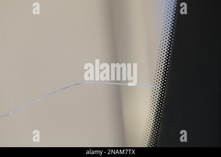 Cracked windshield in the car, close-up of scratches on the glass. Stock Photo