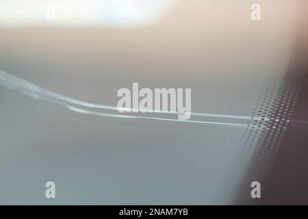 Cracked windshield in the car, close-up of scratches on the glass. Stock Photo