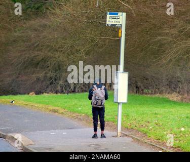 Grim Drumchapel housing estate poverty shots teenager at bus stop Stock Photo