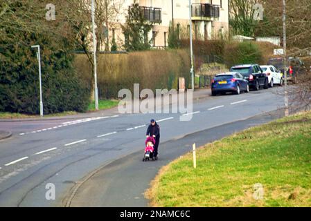 Grim Drumchapel housing estate poverty shots lone parent pushing pram Stock Photo