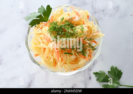 Homemade sauerkraut with carrots, dill in a plate on a light background. Fermented foods. A natural prebiotic. Stock Photo