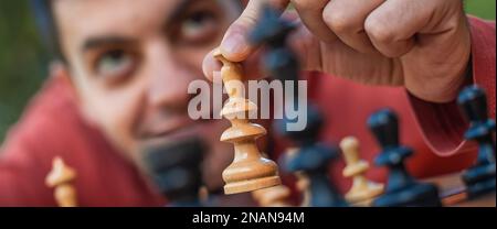 Hand Of A Man Taking A Chess Piece To Make The Next Move In A Chess Game.  Close Up. Spring Day Outside. Stock Photo, Picture and Royalty Free Image.  Image 198493516.