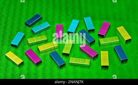 multi colored metal staples on green abstract background Stock Photo