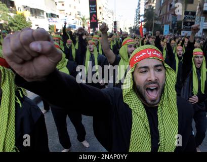 Lebanese Hezbollah supporters shout slogans as they march during ...