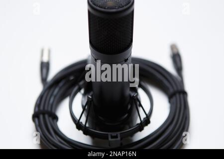 Professional condenser microphone and wire in close up. High quality audio equipment for sound recording studio Stock Photo
