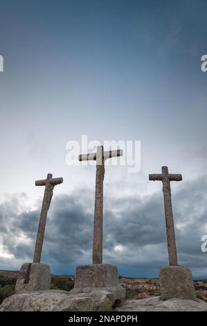 Silhouette of three religious crosses carved in stone with sky at dusk Stock Photo