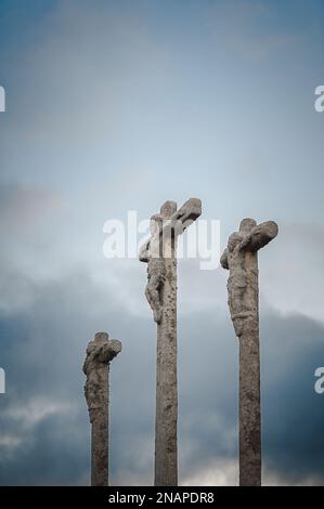 Silhouette of three religious crosses carved in stone with sky at dusk Stock Photo