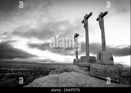 Silhouette of three religious crosses carved in stone with sky at dusk Stock Photo