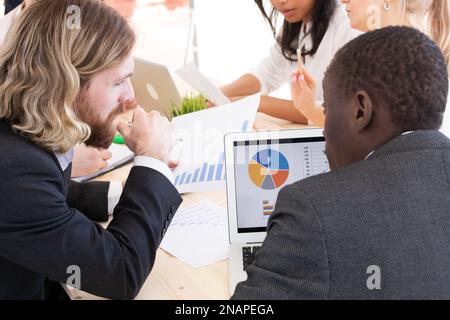 Group of business people meeting at office for analyzing data by using tablet and laptop and discussing for planning strategy and brainstorming for ne Stock Photo