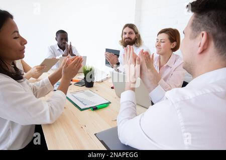 Group of business people applauding sitting at the negotiating table Stock Photo