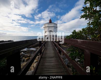 Wooden pathway boardwalk leading to old historical white Stirling Point lighthouse nautical navigation building in Bluff Invercargill Southland South Stock Photo