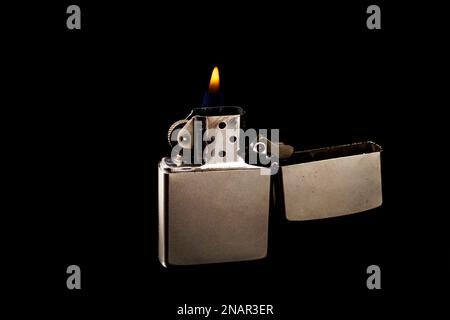 Fire in a metal lighter on a black background Stock Photo