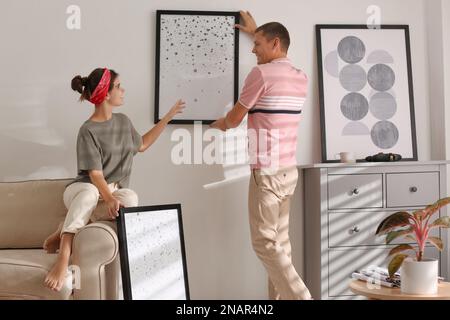 Couple decorating room with pictures together. Interior design Stock ...