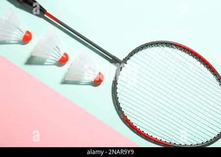 Badminton racket and shuttlecocks on color background, flat lay Stock Photo