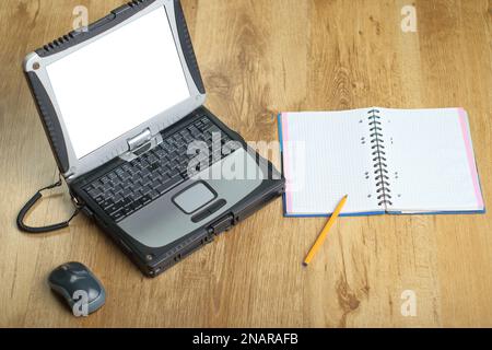 laptop with notebook and pen on panels next to mouse diagonally Stock Photo
