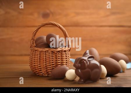 Chocolate Easter bunny and eggs on wooden table Stock Photo
