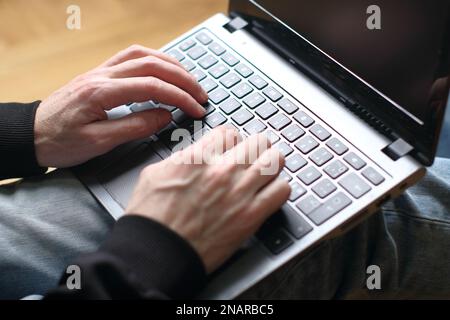 person is typing on a laptop keyboard Stock Photo