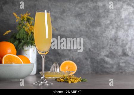 Glass of Mimosa cocktail on grey table. Space for text Stock Photo