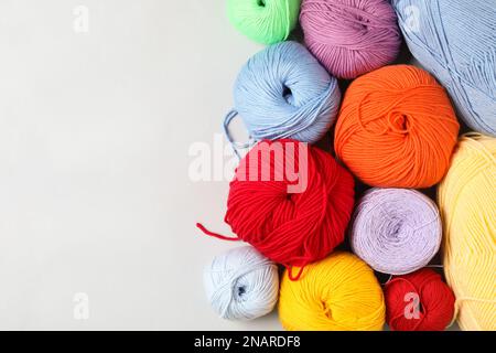 Different colorful woolen yarns on white background, flat lay. Space for text Stock Photo