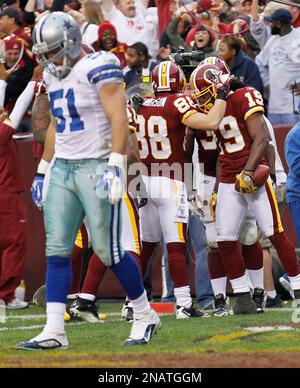 Washington Redskins wide receiver Donte' Stallworth (19) is tackled by New  England Patriots cornerback Devin McCourty (32), rear, Julian Edelman (11)  during the first half at FedEx Field in Landover, MD, Sunday