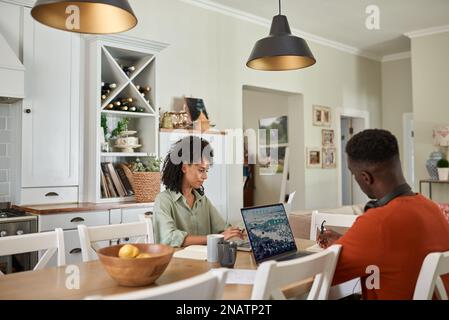 Multiracial couple working online from home using laptops Stock Photo