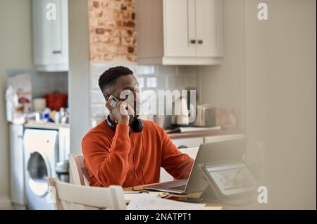 Businessman talking on his phone while working remotely from home Stock Photo