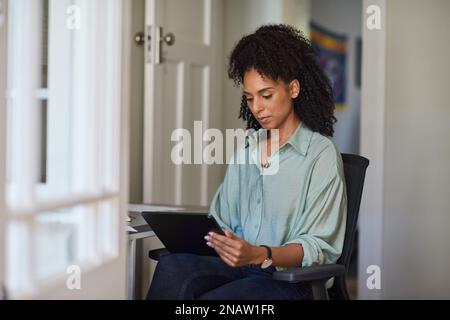 Young businesswoman using a tablet in her home office Stock Photo