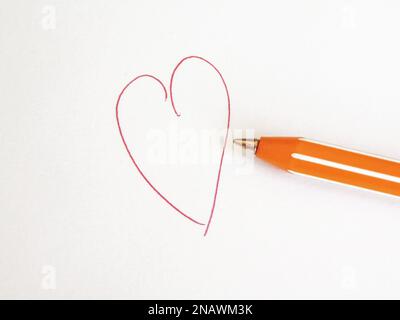 The shape of a heart made on paper with a pen writing in red color Stock Photo