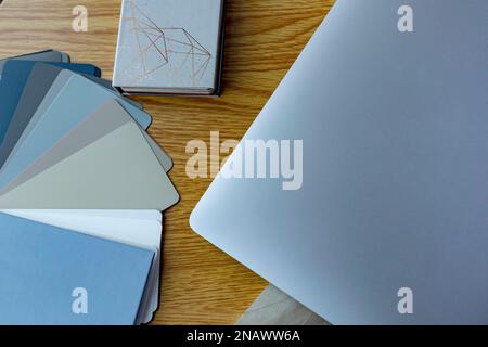 top view of sheet of paper, smartphone, notebook, colors samples, lagurus spikelets and laptop on beige background Stock Photo