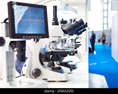 Stereo microscopes with computers monitor on exhibition Stock Photo